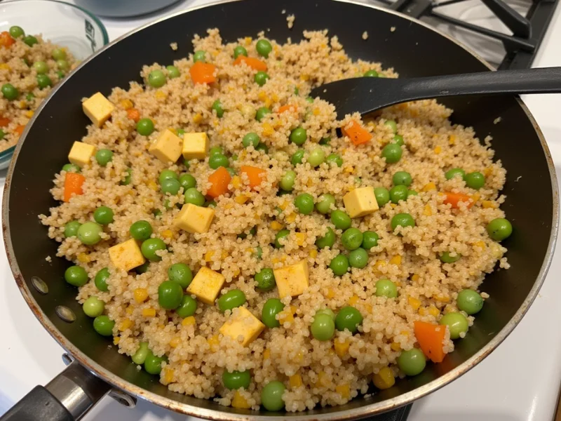 Quinoa-Pfanne mit gebratenem Tofu, Gemüse wie Brokkoli, Karotten und Paprika in einer Pfanne.